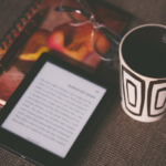 An ebook reader next to a mug