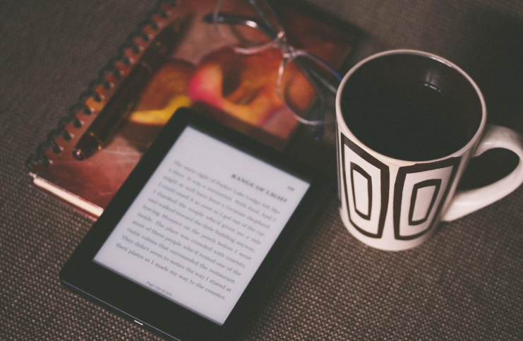 An ebook reader next to a mug